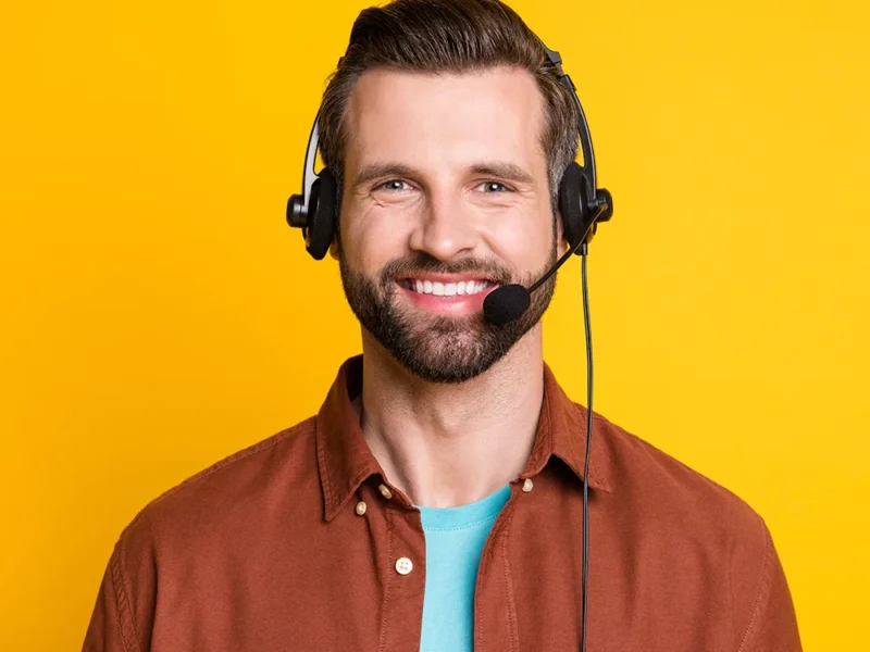 A male US Answering Service virtual receptionist on a yellow background.